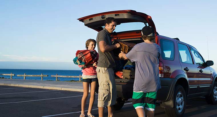family car insurance at beach unpacking car